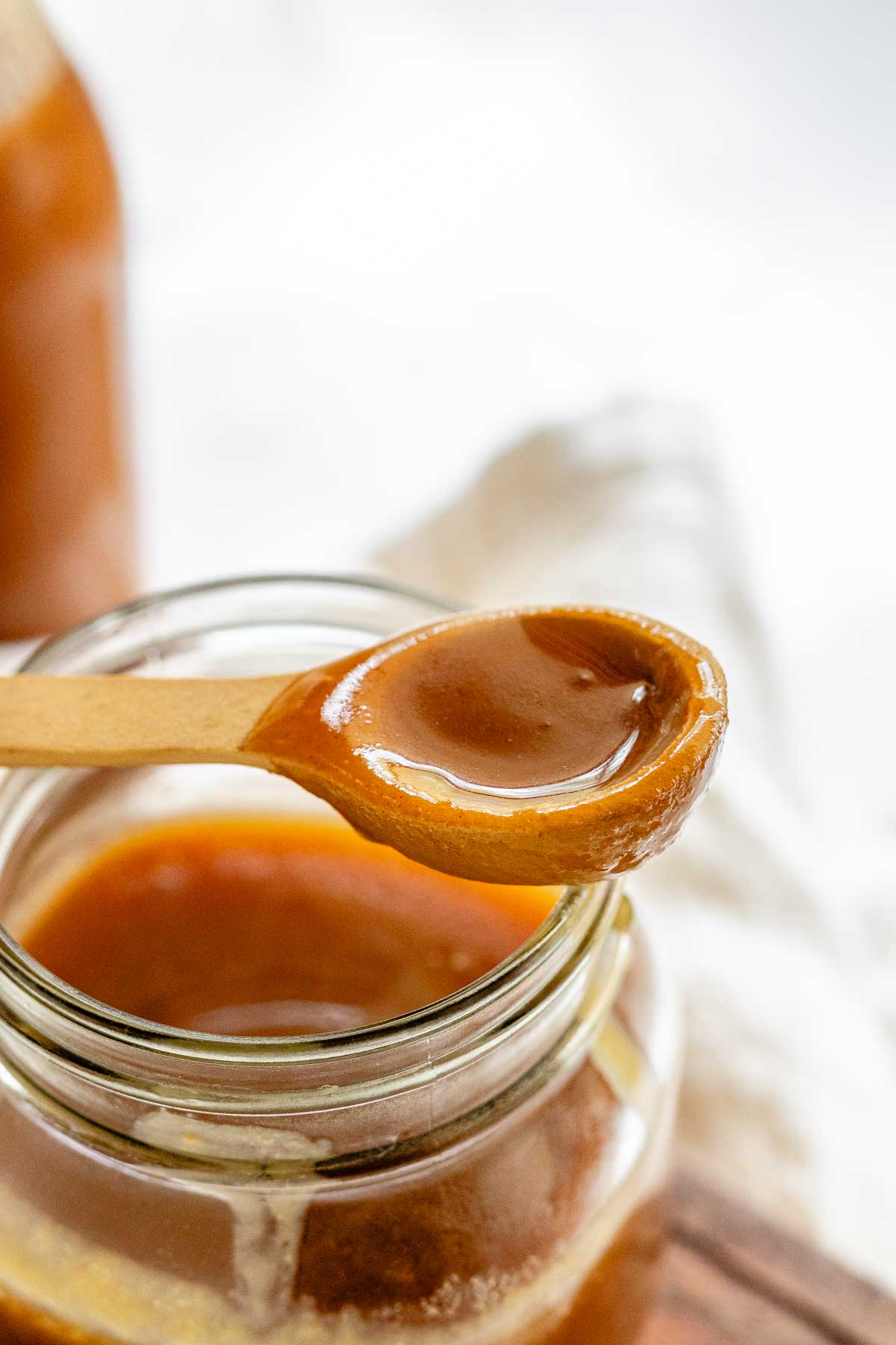 Homemade peanut butter syrup in a glass jar.