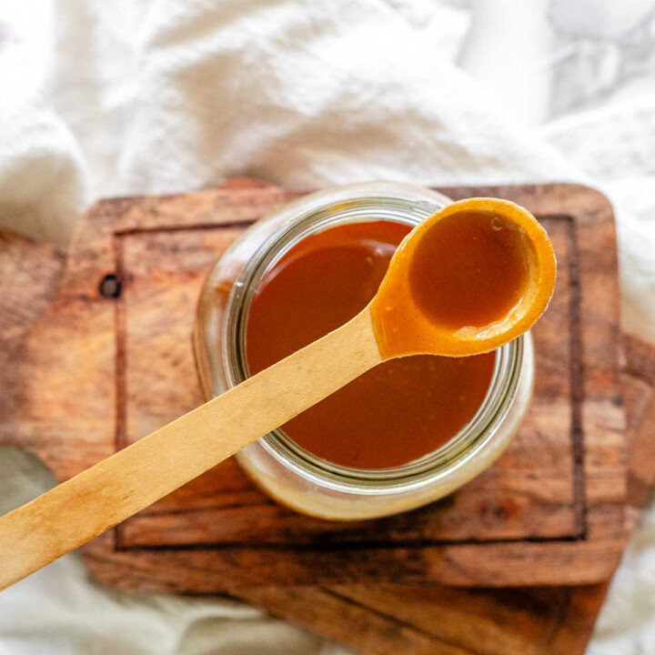 Homemade peanut butter syrup in a glass jar.