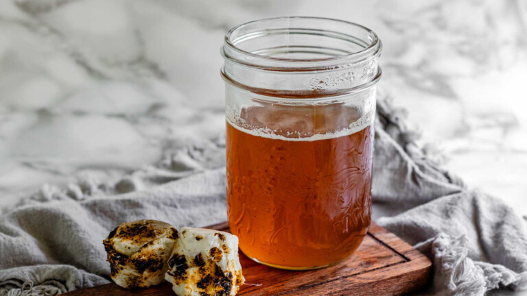 Toasted marshmallow syrup in a glass jar with toasted marshmallows.