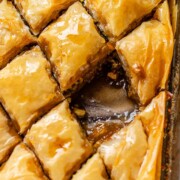 A baking dish of diamond-cut flaky pastry with one piece missing.