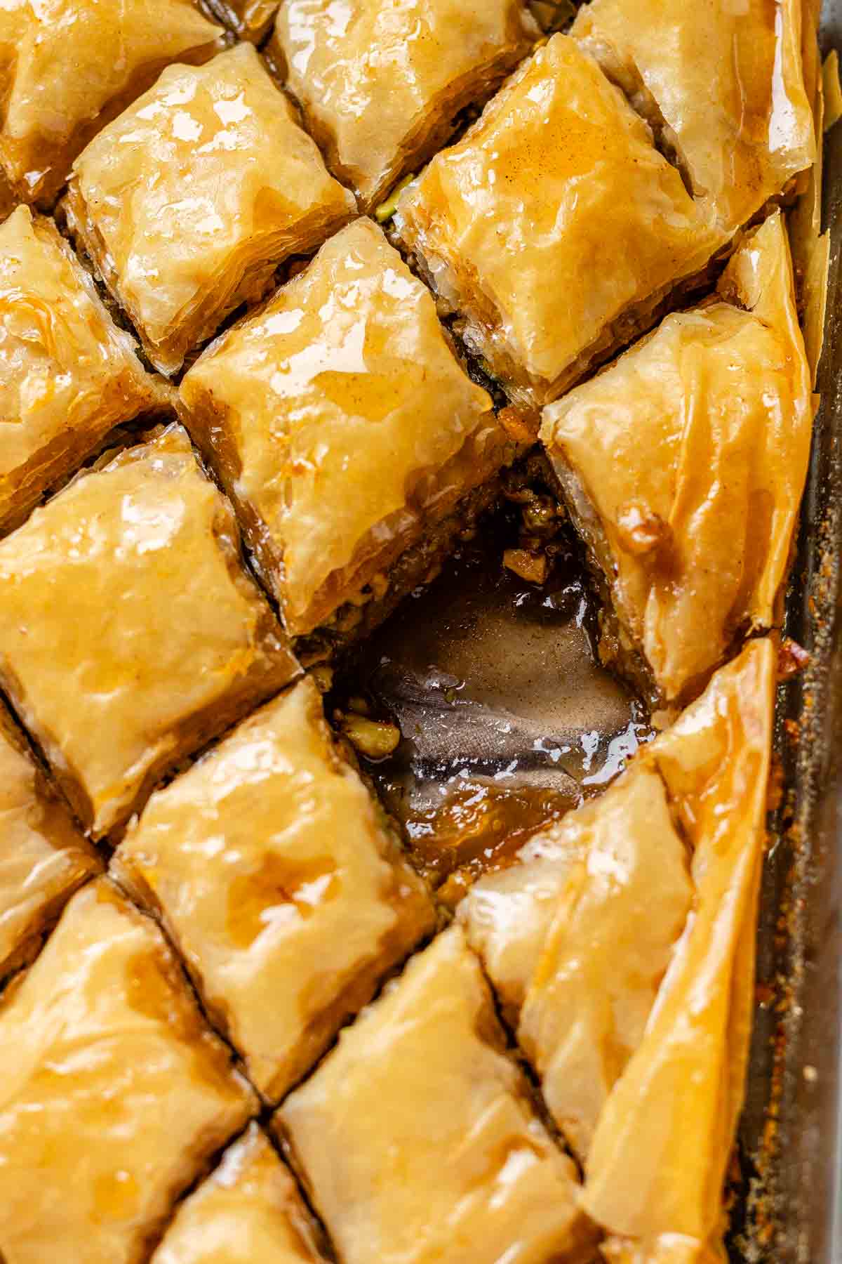 A baking dish of diamond-cut flaky pastry with one piece missing.