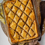 A baking dish of diamond-cut flaky pastry with the text pistachio baklava.