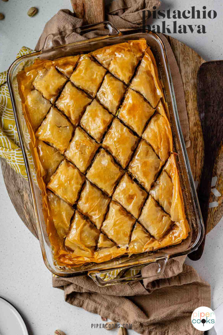 A baking dish of diamond-cut flaky pastry with the text pistachio baklava.