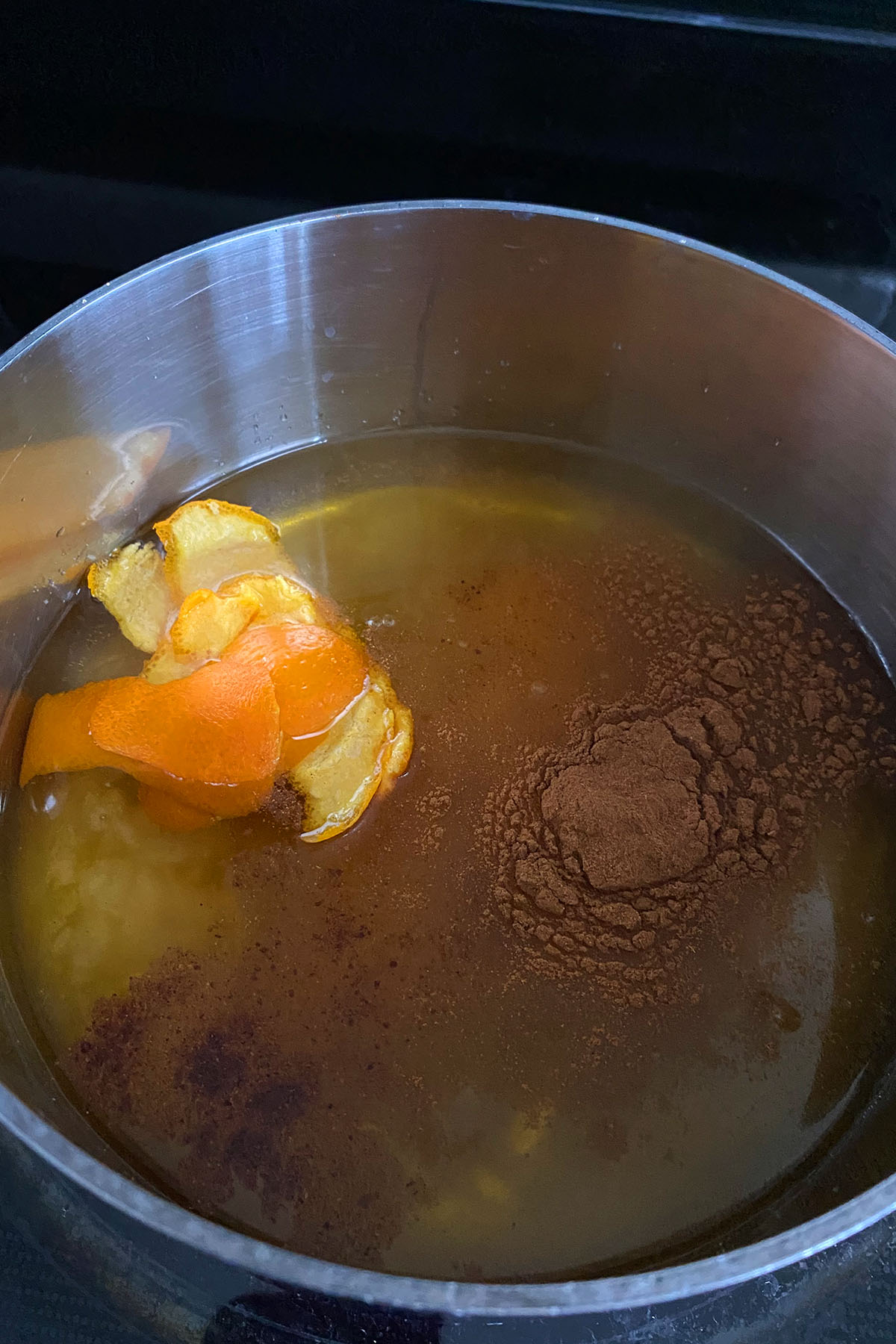 Honey orange syrup simmering in a saucepan for baklava