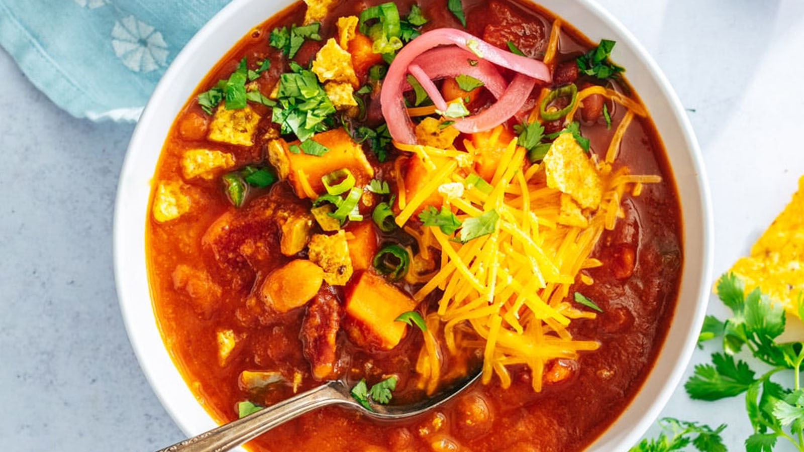 Chili in a bowl with various toppings.
