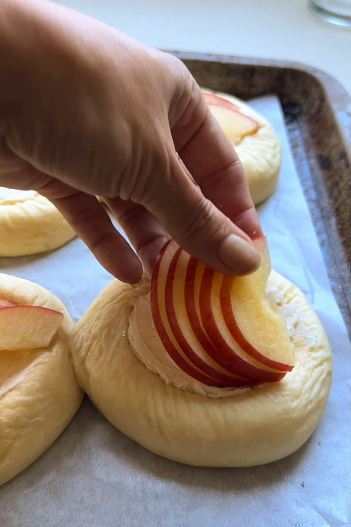 Apple slices are placed on top of a flattened dough round.