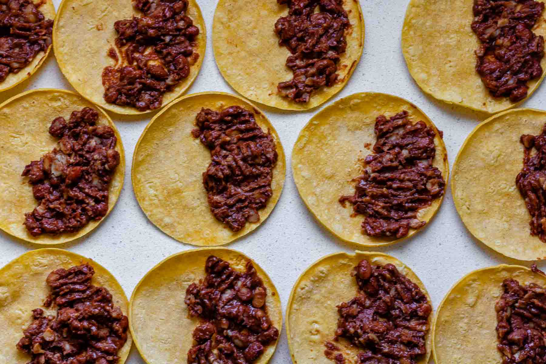 Corn tortillas with beans on one side.