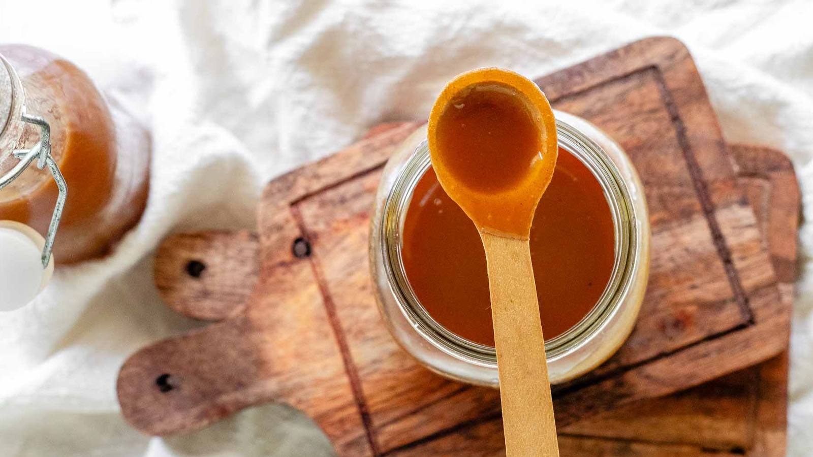 Homemade peanut butter syrup in a glass jar.